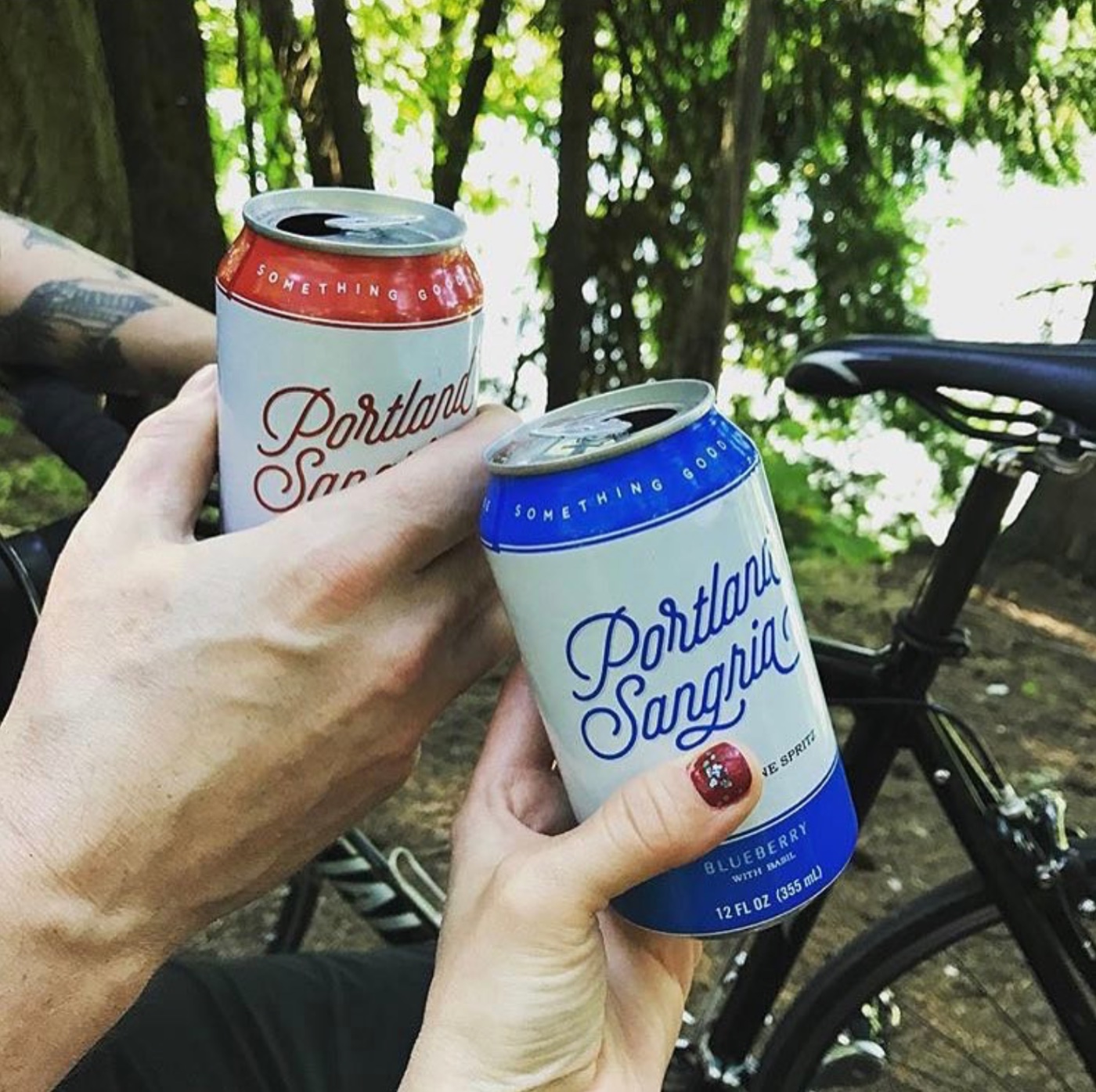 Raspberry and Blueberry cans toasting on a forest bike trail